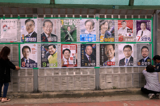 20일 오후 광주 북구에서 북구청 주민센터 직원들이 대선후보들의 벽보를 부착하고 있다.